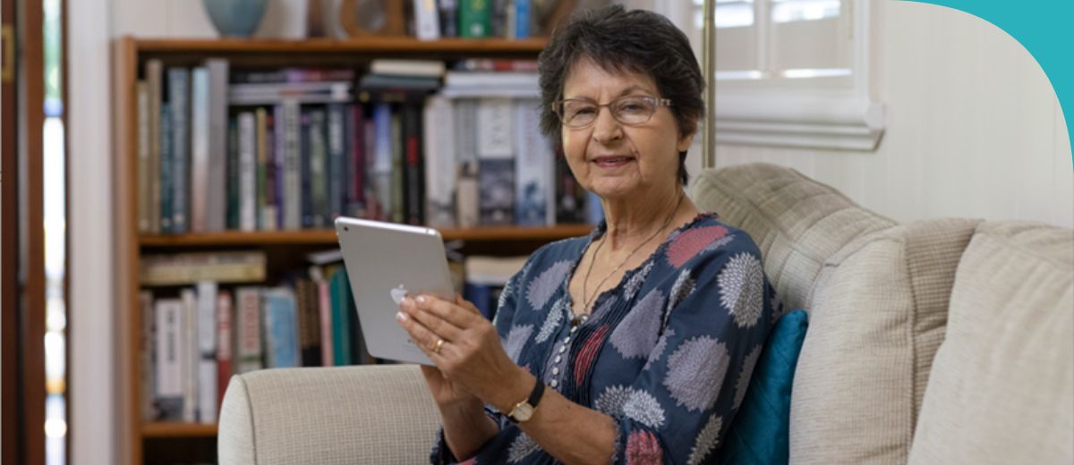 An older lady typing on her laptop