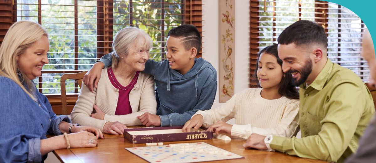 A group of people of different ages sit around a table playing a game