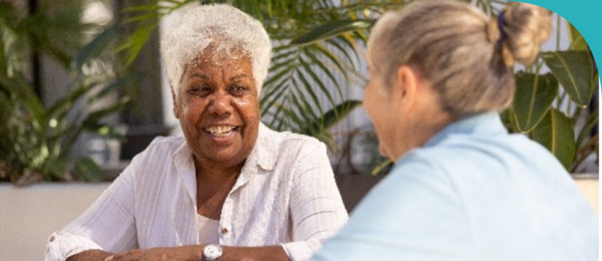 One lady looking at another lady and smiling